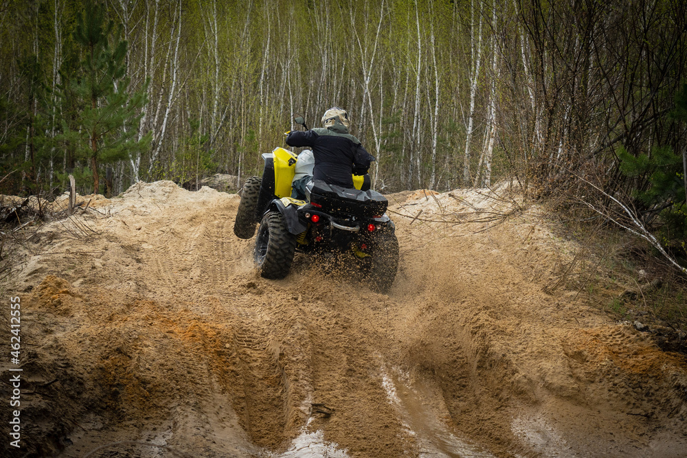 ATV/UTV/4x4 rider throw splashing past a muddy puddle ATV/UTV/4x4 rider throw splashing past a muddy puddle