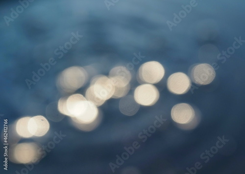 Defocused sunlight flashes in water. Abstract background with light reflections. Environment and ecology