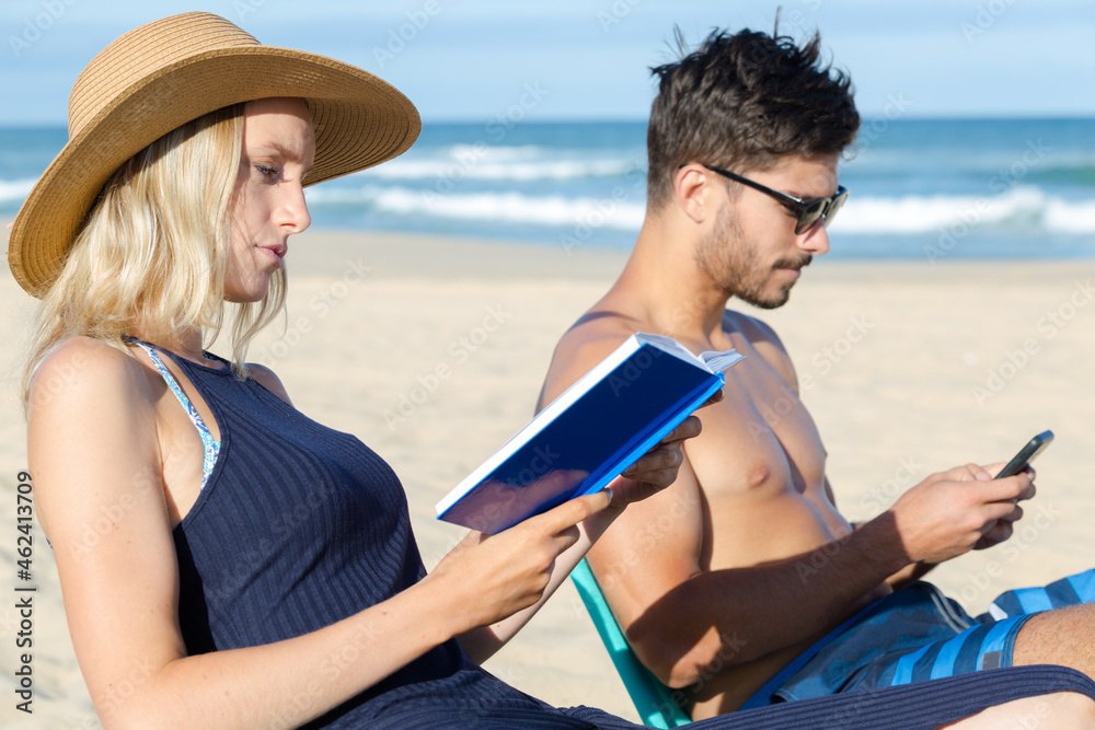 Fototapeta premium couple on holidays reading and using the phone