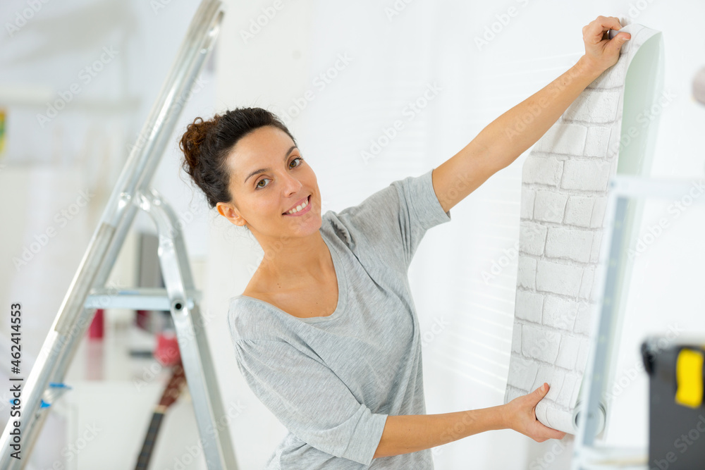 girl putting photo frame on wall girl putting photo frame on wall