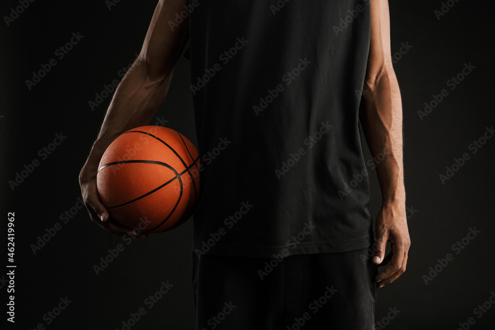 Young athletic sportsman posing with basketball Young athletic sportsman posing with basketball
