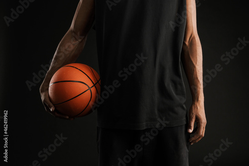 Young athletic sportsman posing with basketball