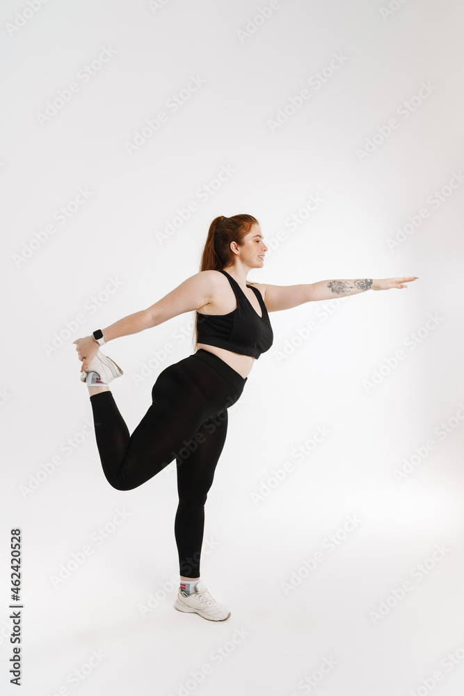 Smiling young plus size fitness woman in sportswear