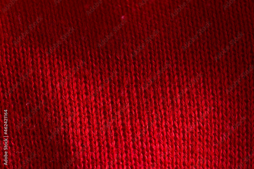 Fototapeta premium Red knitted sweater close-up. Material background, macro