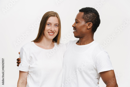 Multiracial couple wearing t-shirts smiling and hugging