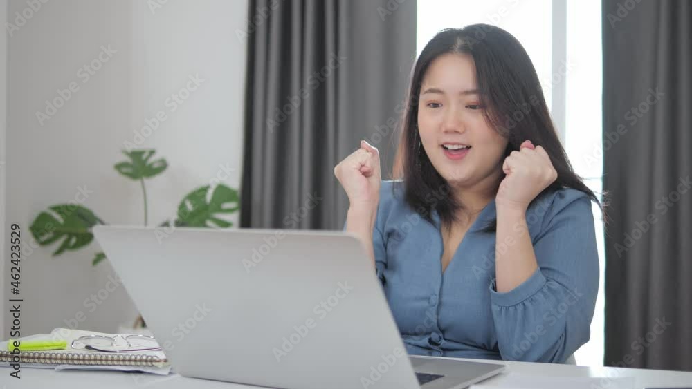Happy excited asian woman at home with raised hands, Enjoying time, Beautiful young smiling girl working on laptop , celebrating the success business Happy excited asian woman at home with raised hands, Enjoying time, Beautiful young smiling girl working on laptop , celebrating the success business
