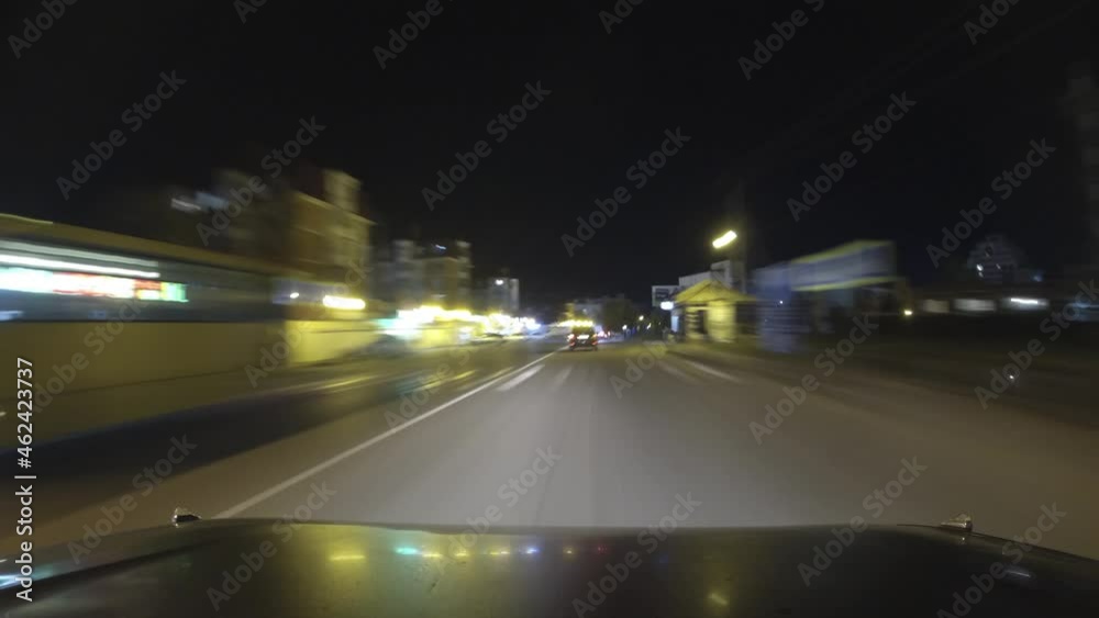 Timelapse car traffic on a small town street at night. Glimpses of lights from other cars, signs, and city lights Timelapse car traffic on a small town street at night. Glimpses of lights from other cars, signs, and city lights
