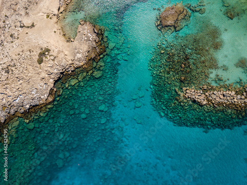 Aerial view from flying drone on clear blue water of bay in Cyprus