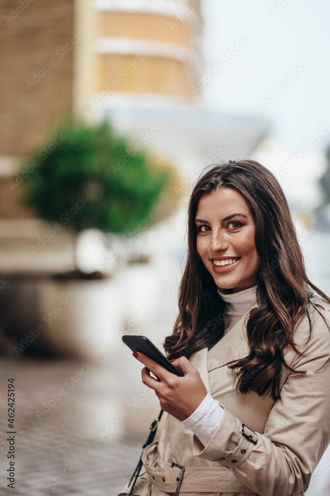 Beautiful young woman using a smartphone while out in the city Beautiful young woman using a smartphone while out in the city