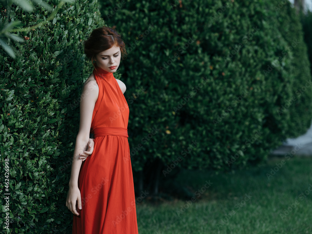 woman in red dress walking in the garden gothic nature