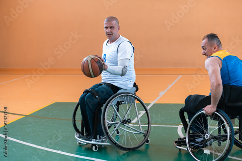 a photo of a war veteran playing basketball with a team in a modern sports arena. The concept of sport for people with disabilities © .shock