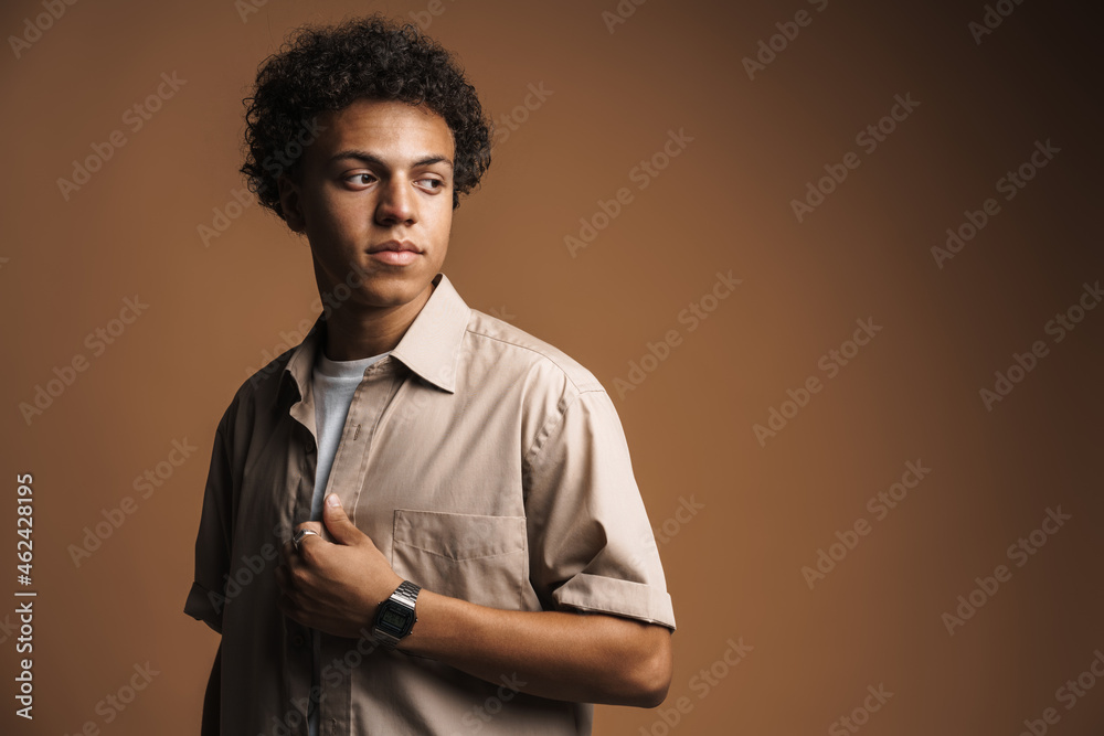 Fototapeta premium Young black man in shirt posing while looking aside