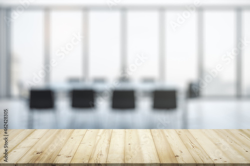 Empty office wooden desktop with empty space on modern boardroom with large window background, closeup, mockup © Pixels Hunter