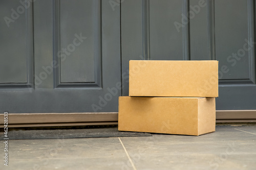 cardboard boxes delivered to the forn door and left outside for contactless pickup, delivery for online shopping, contact-free delivery and pickup due to COVID-19. High quality photo © Alena Yakusheva
