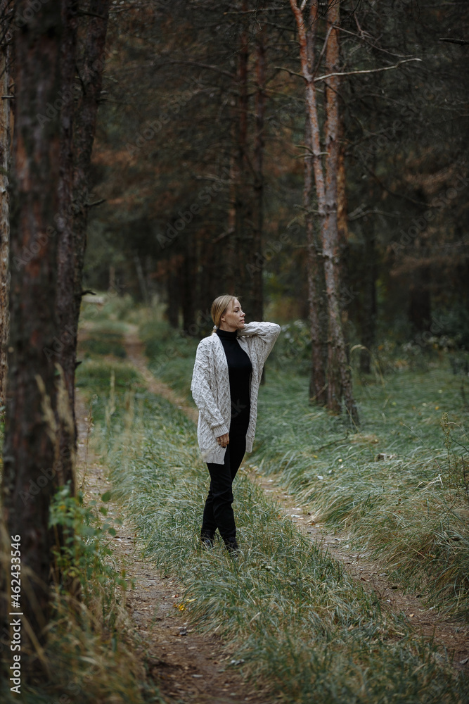 girl in black golf with a gray cape among the autumn forest