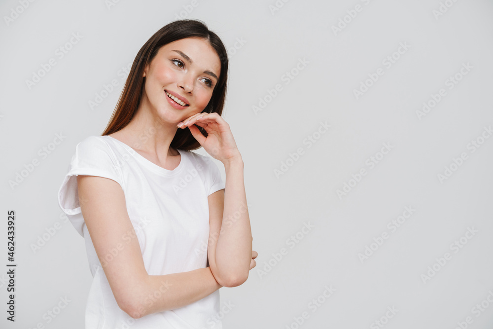 Young brunette woman in t-shirt smiling and looking aside Young brunette woman in t-shirt smiling and looking aside