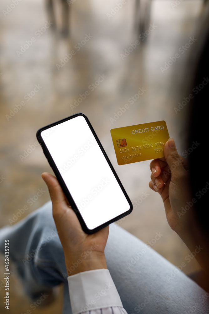 Close up of young Asian woman holding credit card and using smartphone for shopping online with payment on internet banking. Close up of young Asian woman holding credit card and using smartphone for shopping online with payment on internet banking.