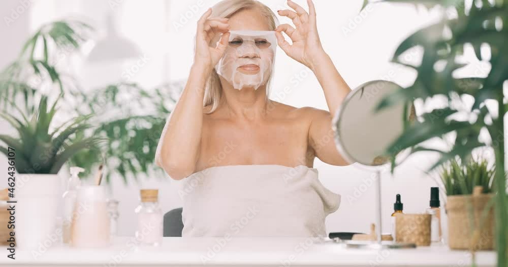 Senior woman sitting at home and putting off beauty mask from her face. Senior woman sitting at home and putting off beauty mask from her face.