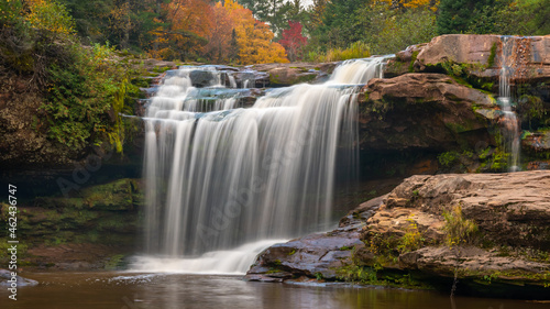 O Kun-de-Kun Falls nestled against an autumn-colored forest  on the Baltimore River  near Bruce Crossing  Michigan.