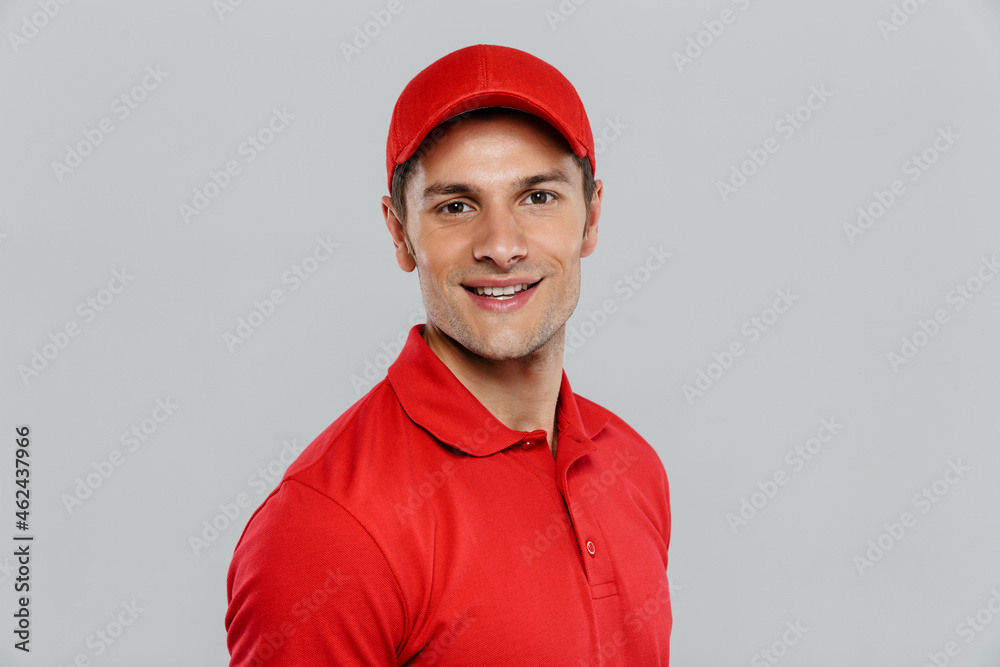 Young delivery man wearing uniform smiling and looking at camera Young delivery man wearing uniform smiling and looking at camera