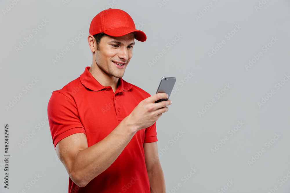 Young delivery man wearing uniform smiling and looking at camera Young delivery man wearing uniform smiling and looking at camera