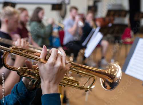 a small jazz band showing close ups of hands on brass instruments