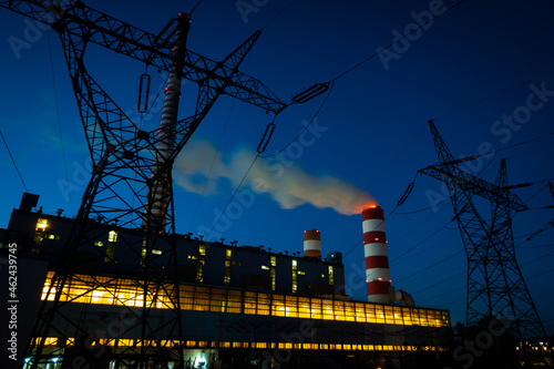 Night picture of the coal-fired power plant. Blurry view for the smoke coming out of the chimneys. Photo taken in evening under natural lighting conditions.