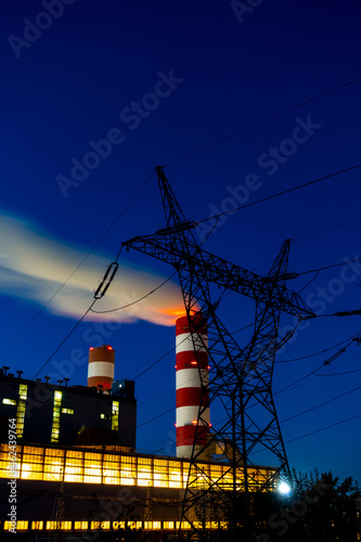 Night picture of the coal-fired power plant. Blurry view for the smoke coming out of the chimneys. Photo taken in evening under natural lighting conditions.