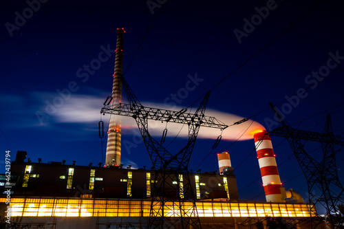 Night picture of the coal-fired power plant. Blurry view for the smoke coming out of the chimneys. Photo taken in evening under natural lighting conditions.