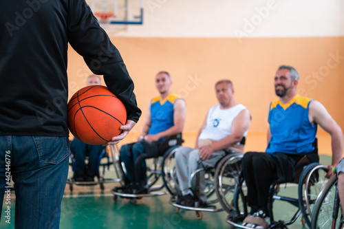 selector I explain new tactics to basketball players in wheelchairs, players sit in wheelchairs listening to the selector
