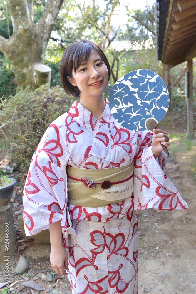 庭先でポーズをとる団扇を手に浴衣を着た若い女性 Stock Photo Adobe Stock