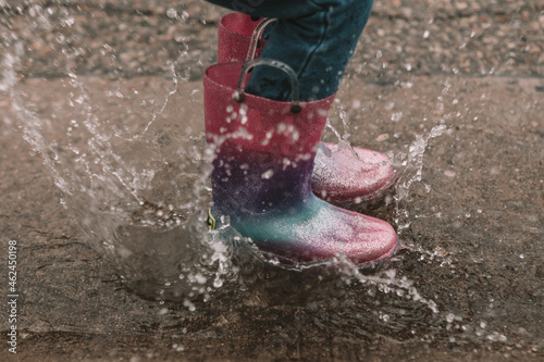Splashing in a buddle in rainbow rainboots photo