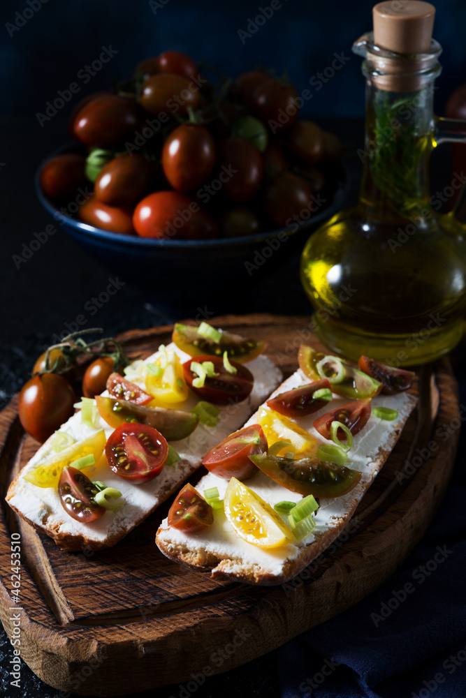 Bruschetta with tomatoes and olive oil on a wooden board - traditional Italian, Spanish snack