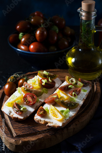 Bruschetta with tomatoes and olive oil on a wooden board - traditional Italian  Spanish snack