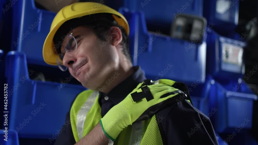 Injured Warehouse Worker With Helmet and Uniform Feeling Shoulder Pain Injured Warehouse Worker With Helmet and Uniform Feeling Shoulder Pain