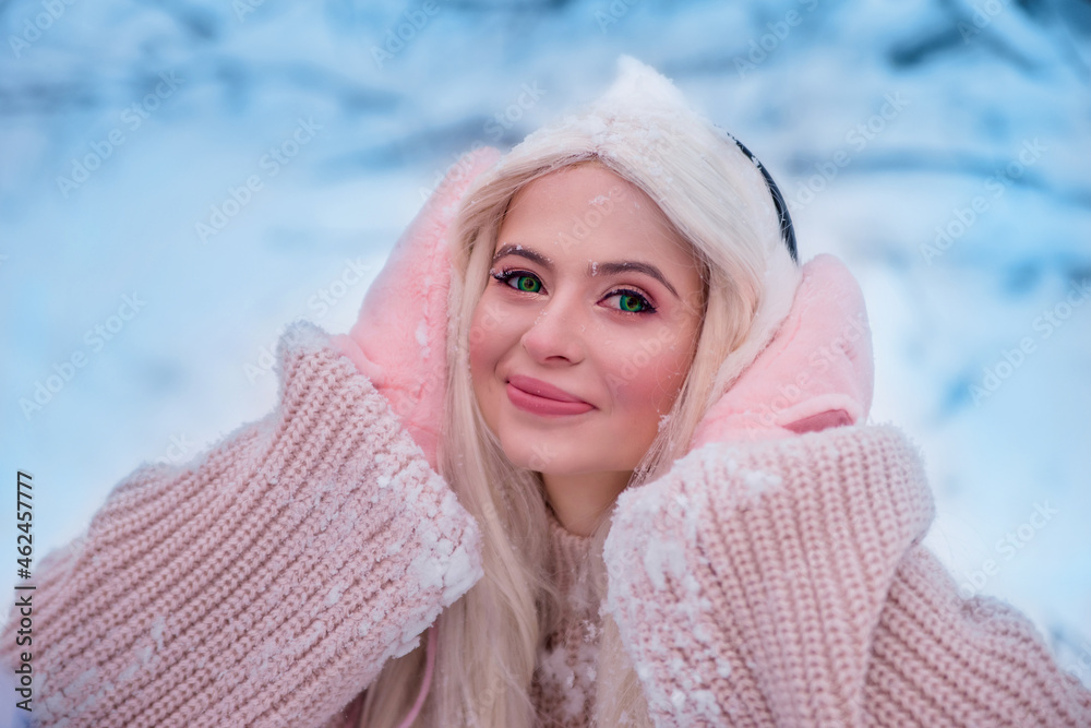 Happy girl rejoices in the snow, close-up portrait. New year concept.