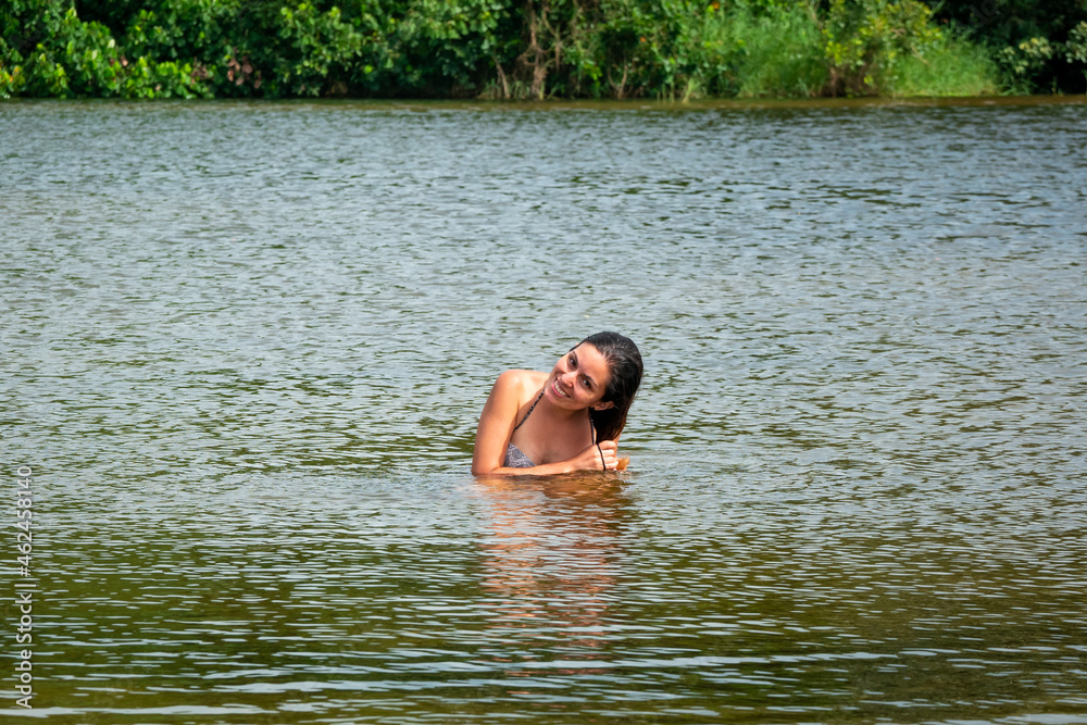 Young Latin Woman is Washing her Hair in San Salvador River, in Palomino, La Guajira, Colombia