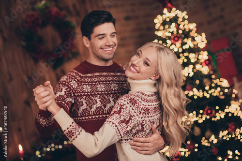 Photo of pretty excited wife husband dressed print pullovers dancing celebrating christmas smiling indoors room home house