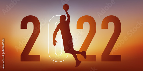 Concept du sport sur le thème du basket pour une carte de vœux 2022, montrant un basketteur sautant le bras tendu pour marquer un panier. photo