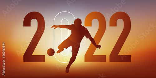 Concept du sport sur le thème du football pour une carte de vœux 2022, montrant un footballeur qui frappe le ballon du pied pour marquer un but.