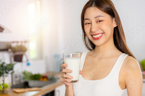 Portrait of Happy Asian healthy woman smiled and holding glass of milk