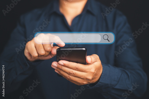 Fototapeta Naklejka Na Ścianę i Meble -  Search engine online concept. Close-up of hand a man in blue shirt using smartphone search for information interest on search engine web site. Technology and internet network concept