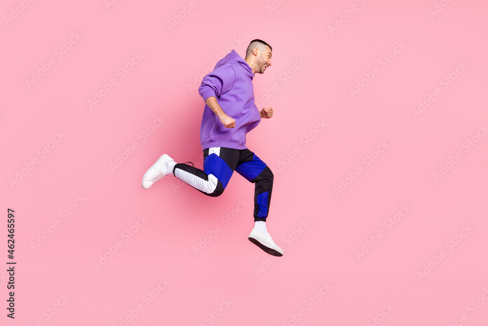 Full body profile photo of cool young brunet guy run wear hoodie pants shoes isolated on pink background