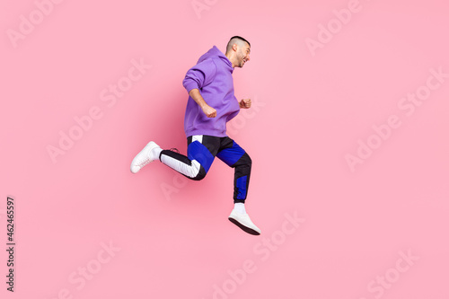 Full body profile photo of cool young brunet guy run wear hoodie pants shoes isolated on pink background © deagreez