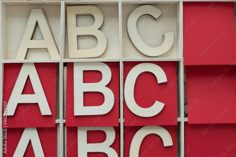 the letters abc repeated in a shallow box with red paper squares the letters abc repeated in a shallow box with red paper squares