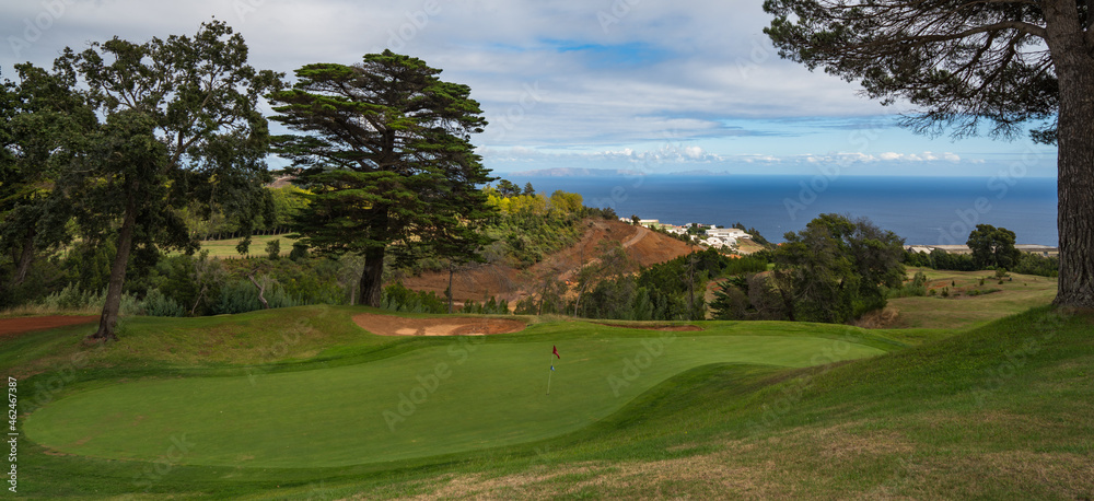 Green with flag, clouds and see at Palheiro golf course on Madeira, Atlantic ocean, Portugal