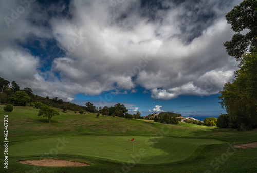 Green with flag  clouds and see at Palheiro golf course on Madeira  Atlantic ocean  Portugal