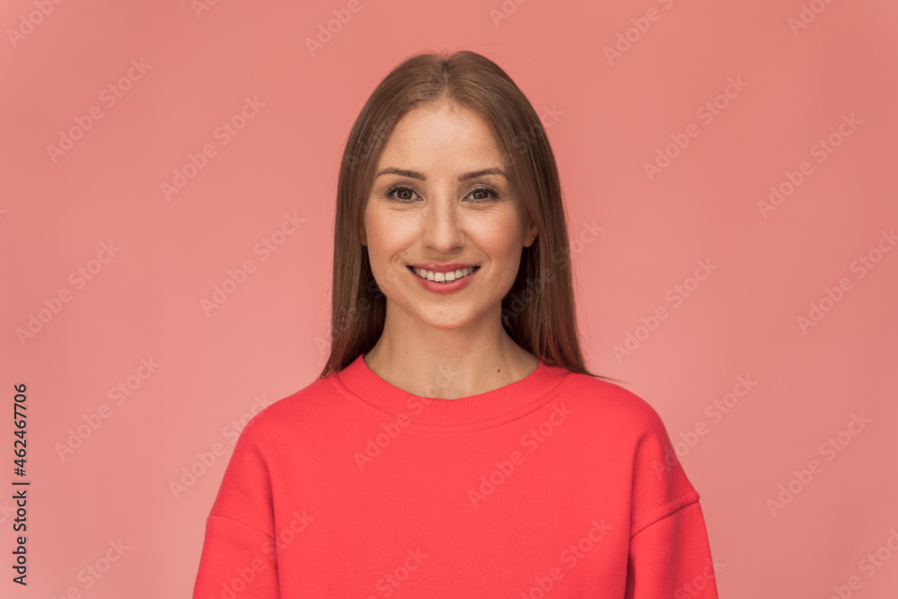 Waist up portrait view of a beautiful happy young woman standing on a pink wall and sincerely smiling. Modern girl smiling broadly at camera, while standing against pink background Waist up portrait view of a beautiful happy young woman standing on a pink wall and sincerely smiling. Modern girl smiling broadly at camera, while standing against pink background