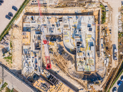 aerial top view of new modern apartment building under construction. yellow cranes working at construction site © netsay