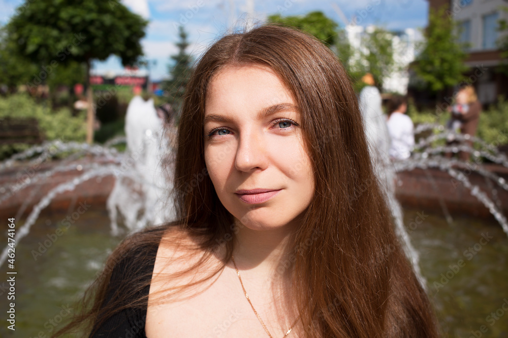 Portrait of a young beautiful woman on the background of a fountain in the city. Portrait of a young beautiful woman on the background of a fountain in the city.